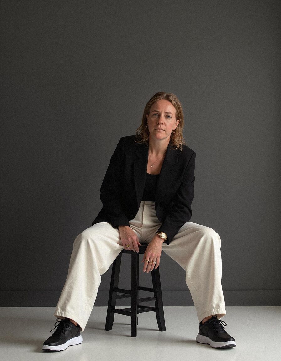 AI headshot of Hannah: studio, dark backdrop, black blazer