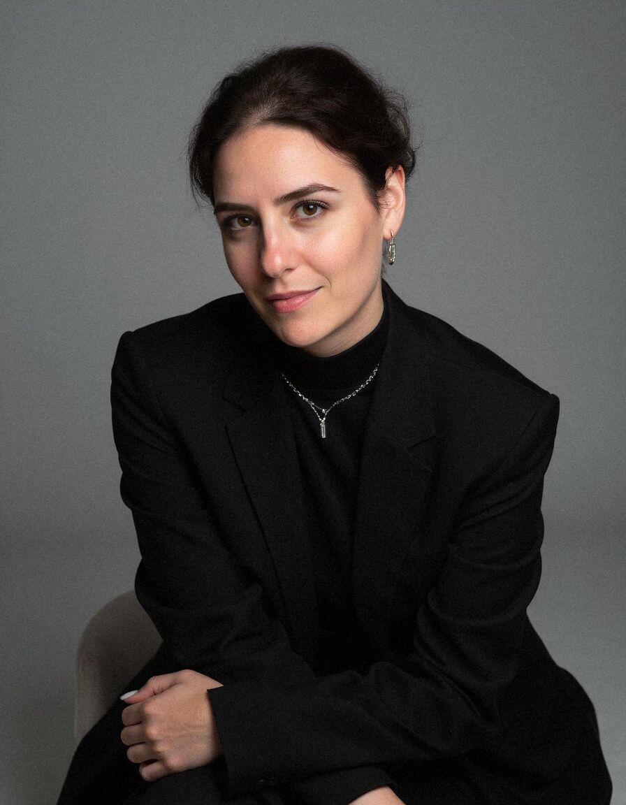 AI headshot of Leila: studio, grey backdrop, black blazer and roll-neck