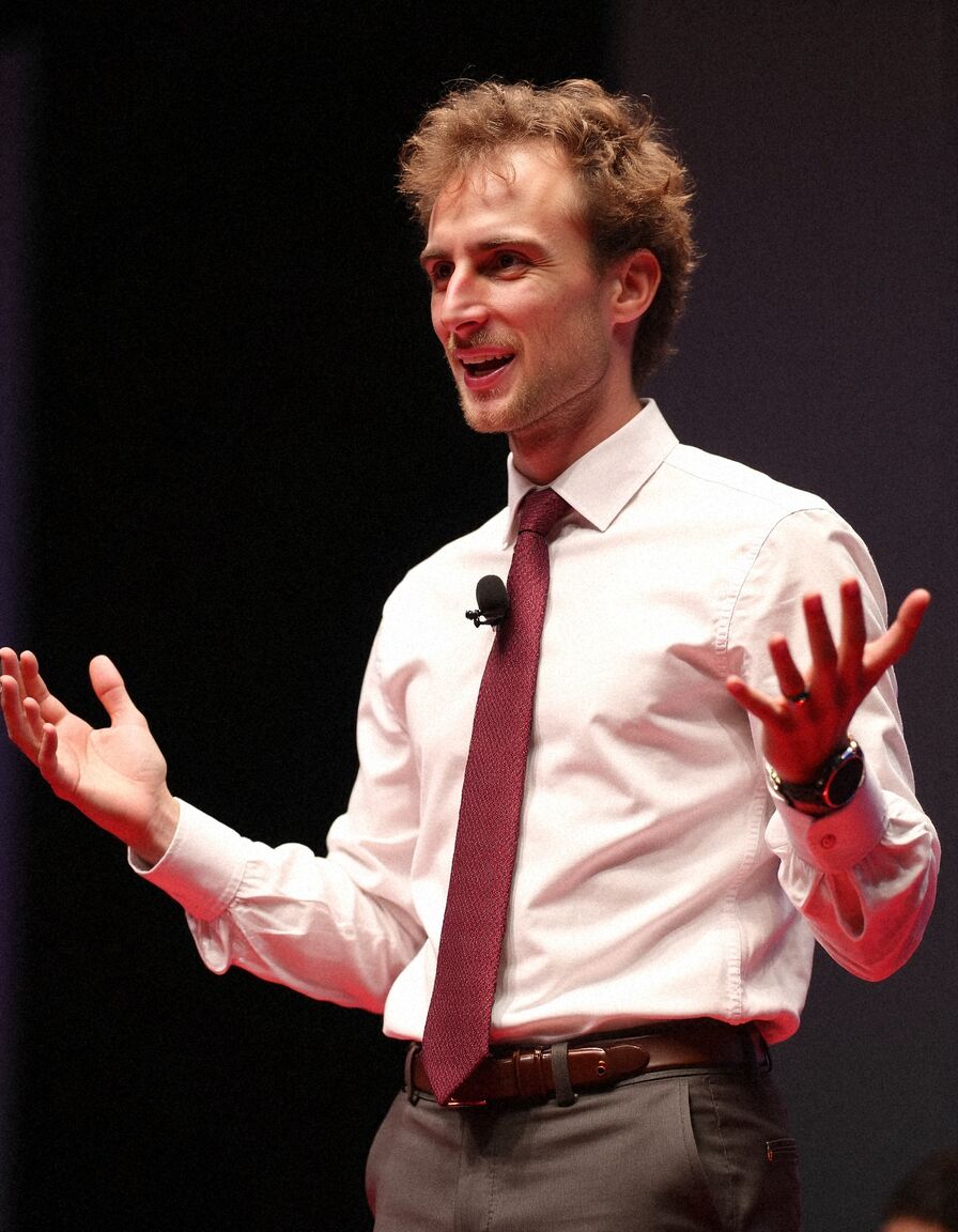 AI headshot of Theo: on stage, white shirt and red tie